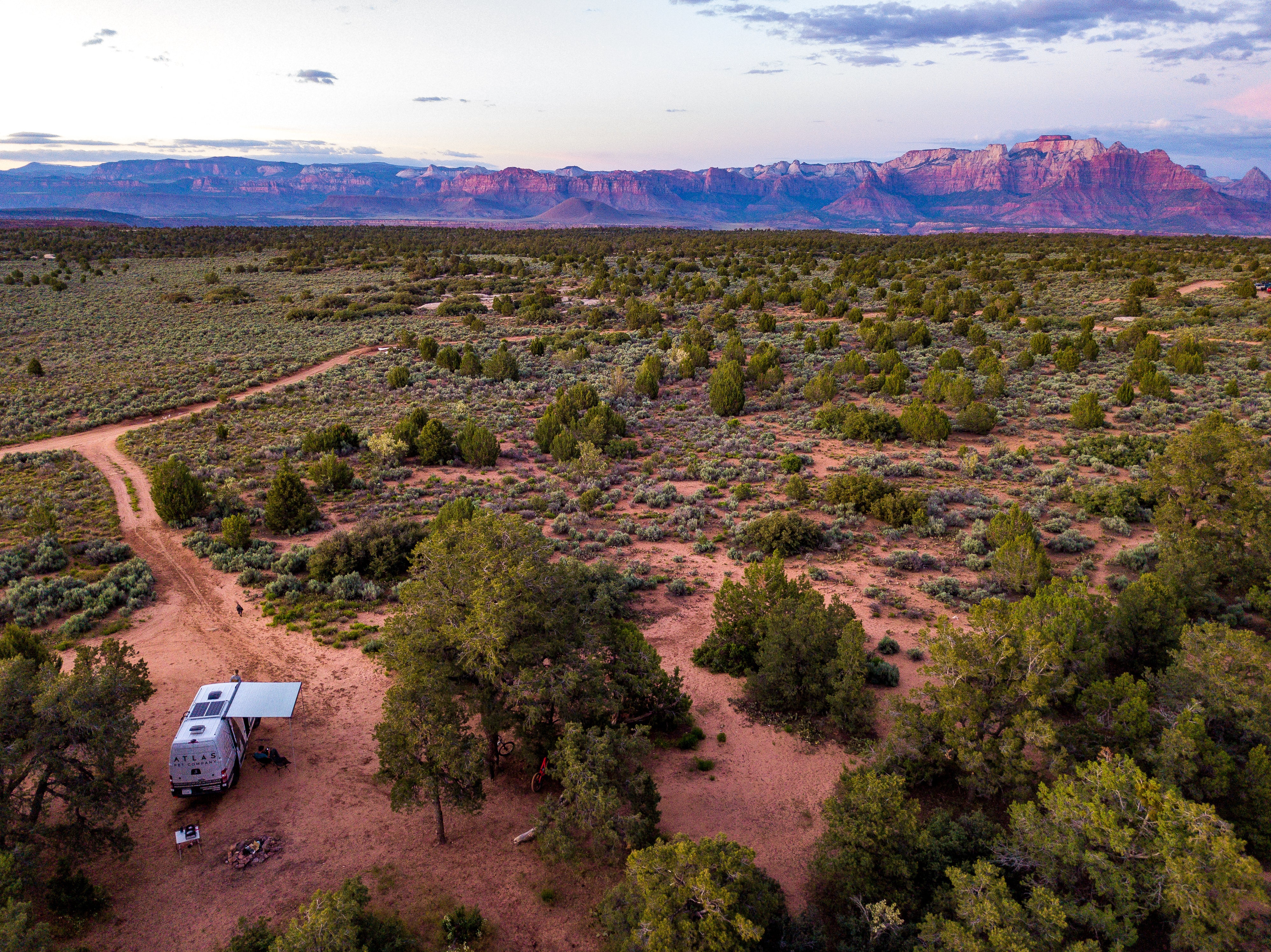 atlas pet company sprinter van in the middle of utah camping on dispersed camping area with mountains of Zion national park in background