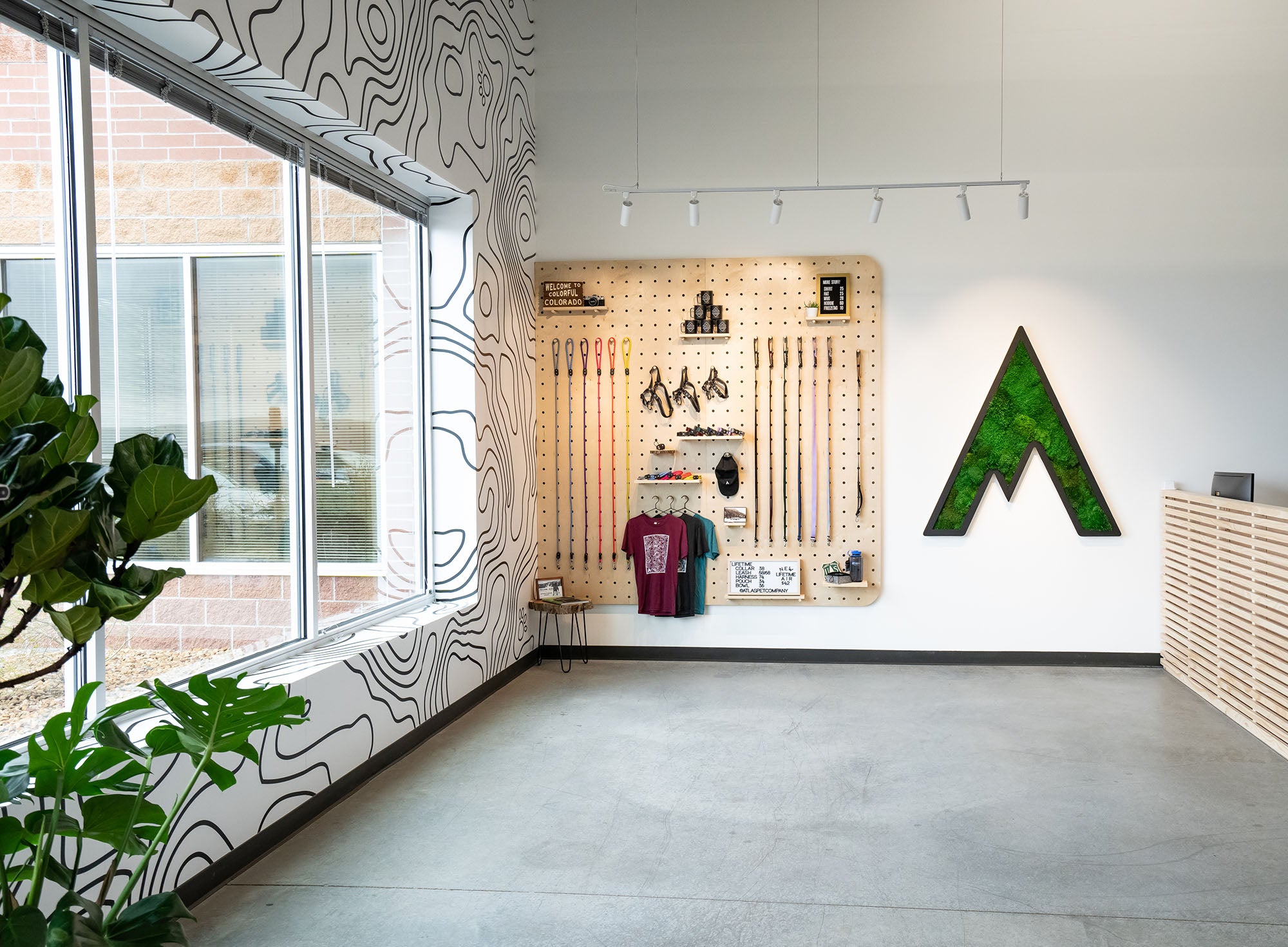 atlas pet company our story page retail storefront at the apc headquarters in Golden Colorado, giant pegboard with large living moss logo