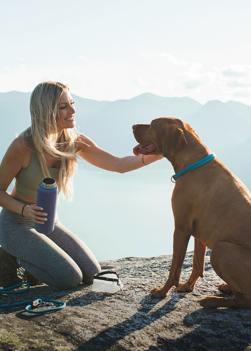 atlas pet company homepage hero with athletic woman and active dog on hike in mountains overlooking lake in the rocky mountains british columbia canada